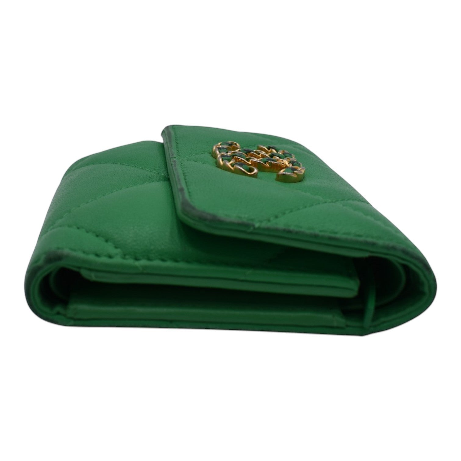 Soldi green quilted compact wallet with gold and green embellishment on the flap.