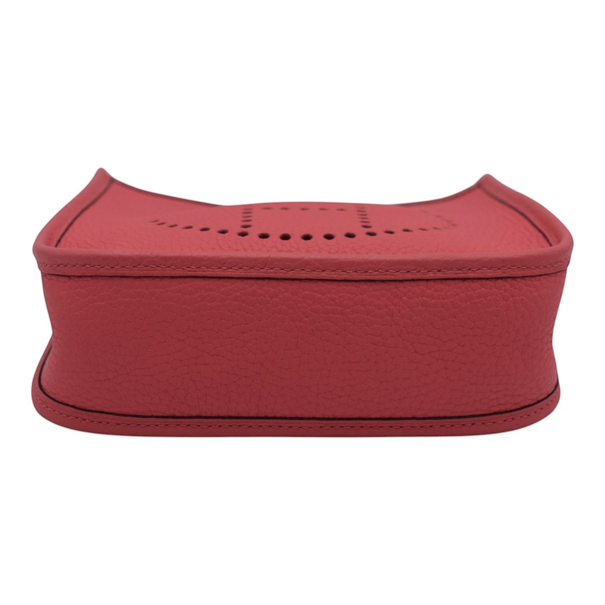 Soldi Hermes Mini Evelyn pink leather crossbody bag with perforated H detail and red strap.