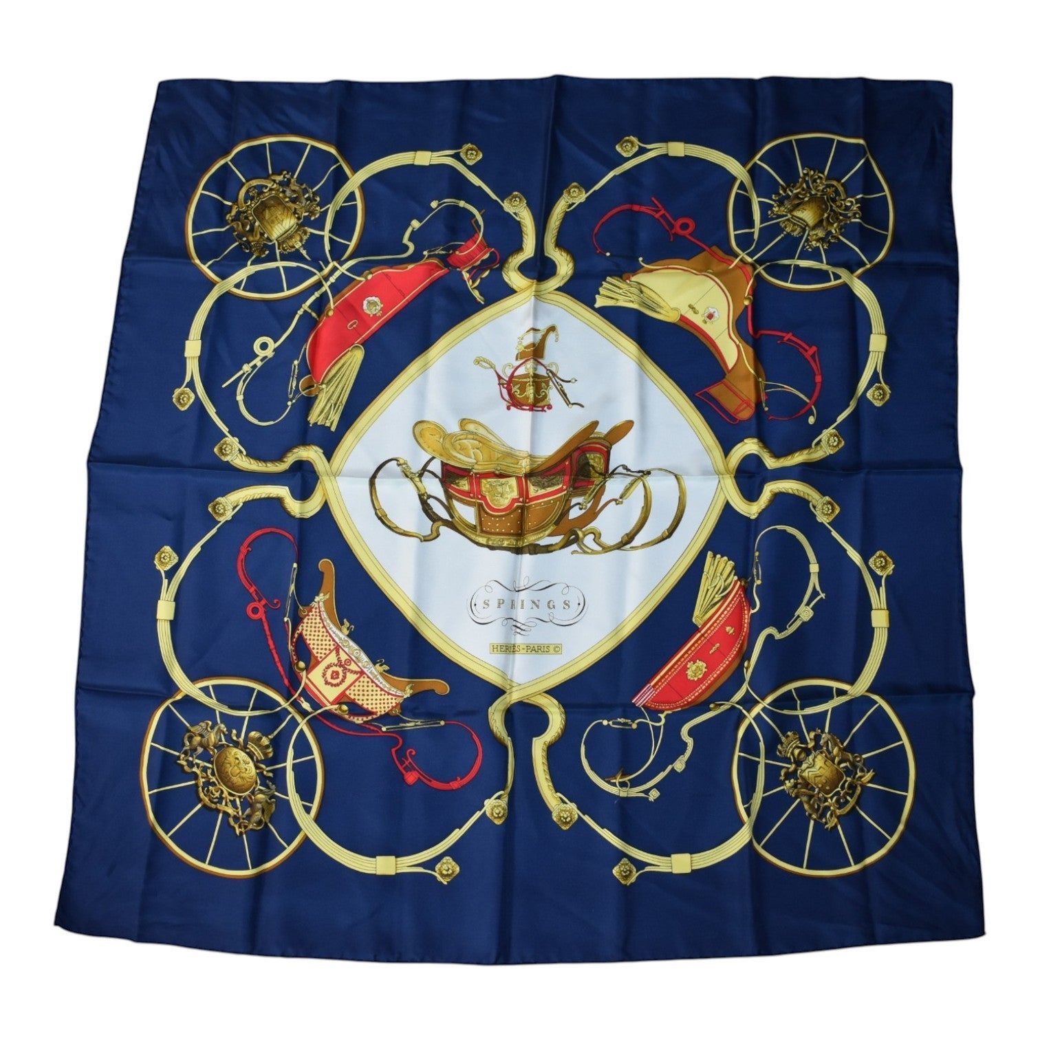 Soldi navy blue silk scarf with gold trim and a central carriage design. Features ornate wheels and red accents.