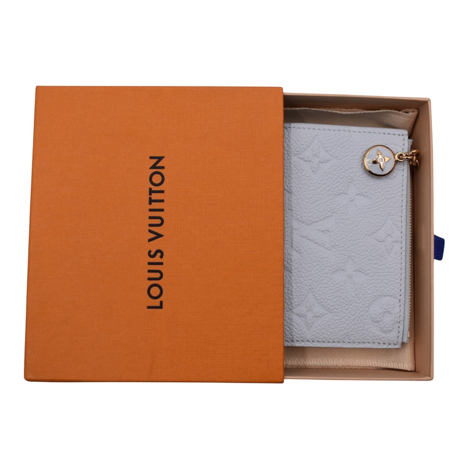 Soldi Baby Blue Empreinte Lisa Wallet with gold charm and zipper detail, presented in a Louis Vuitton box.