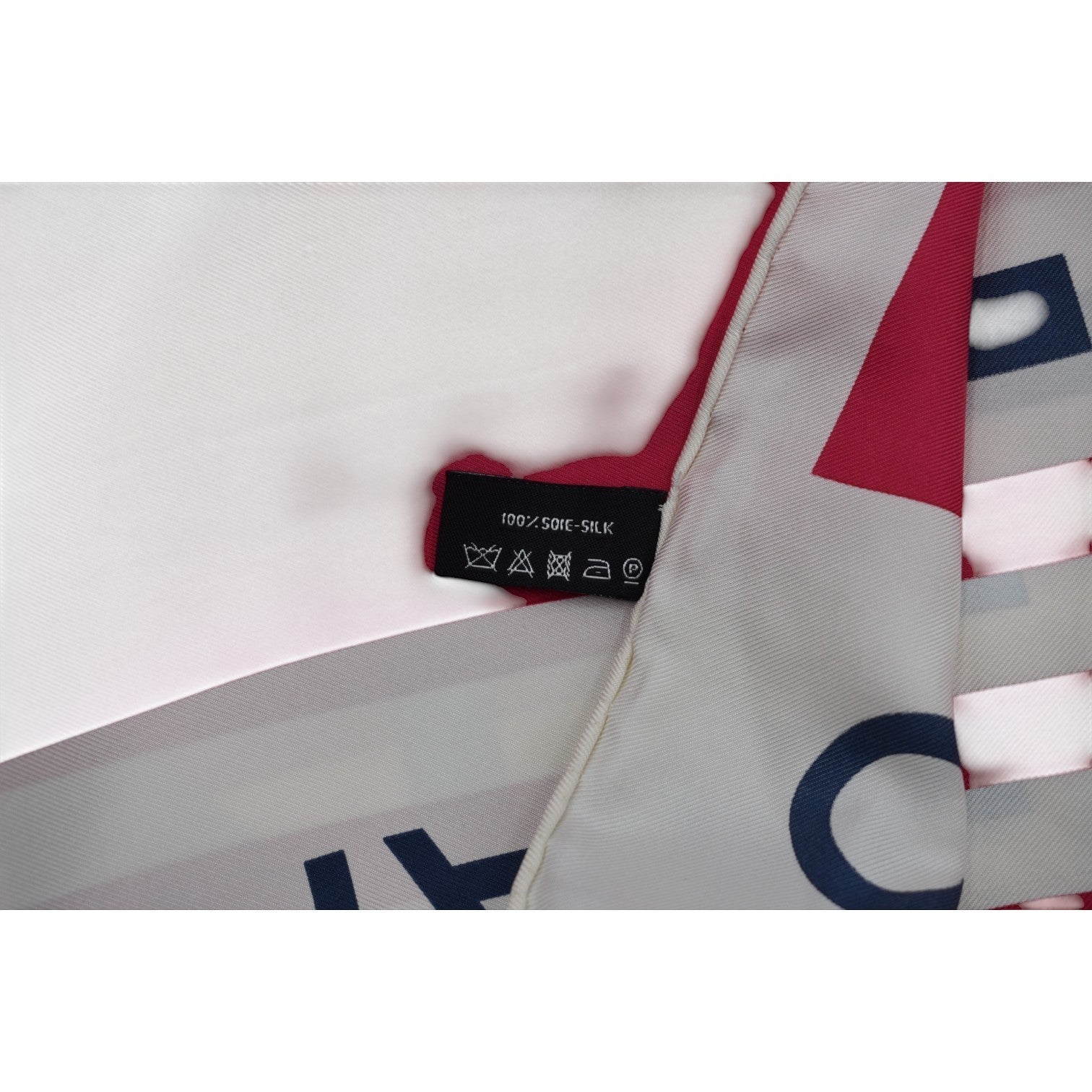 Soldi white silk scarf with red and navy blue geometric pattern and "Cruise 2019" text.