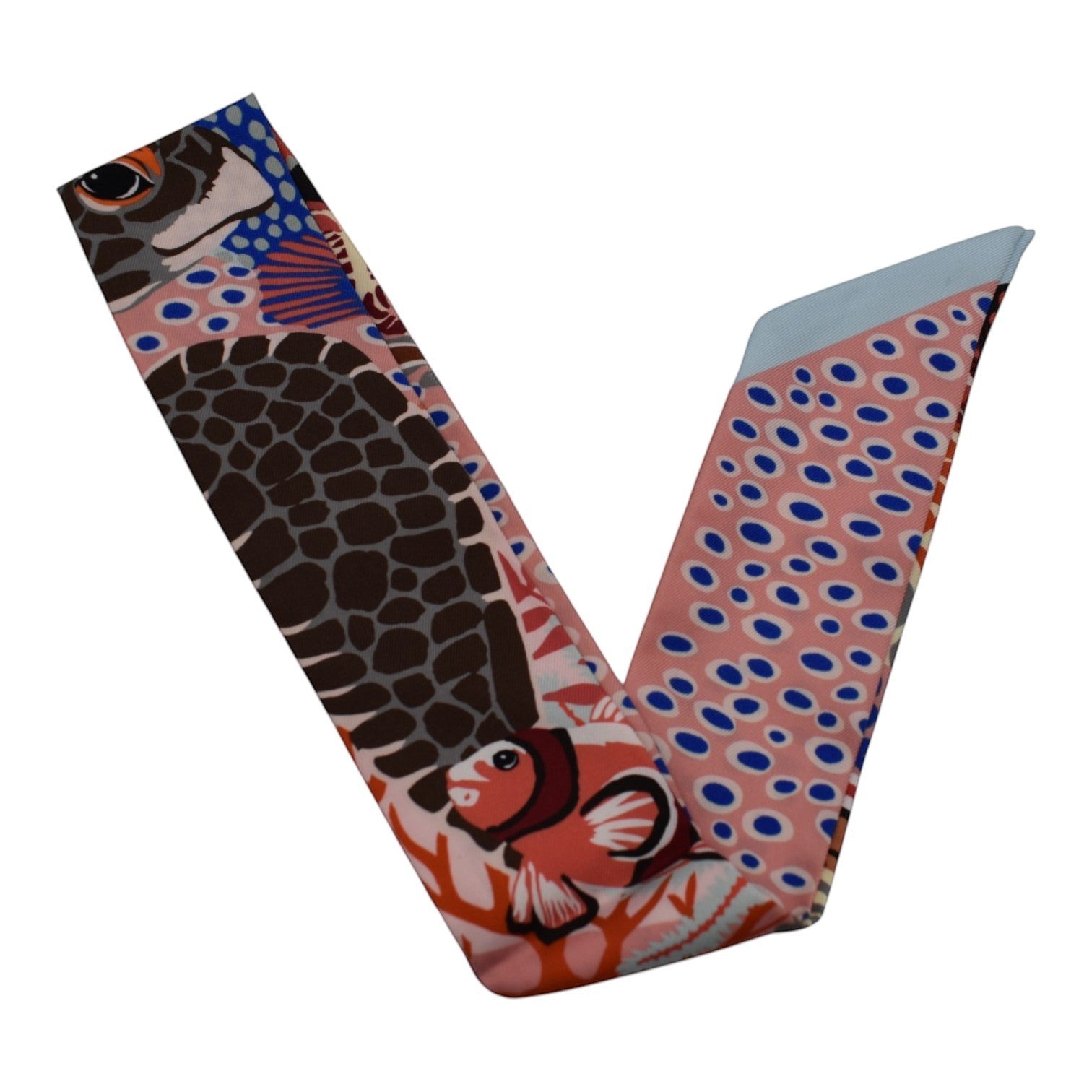 Soldi pink twilly scarf with an underwater scene featuring a turtle, clownfish, and coral. Blue and pink polka dots on one end.